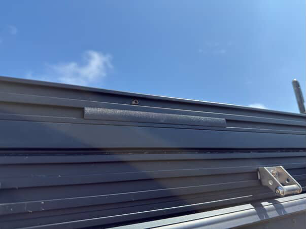 A set of black plastic wire hiders installed on a vehicle roof rack, designed to manage and route wiring along the cross bars.