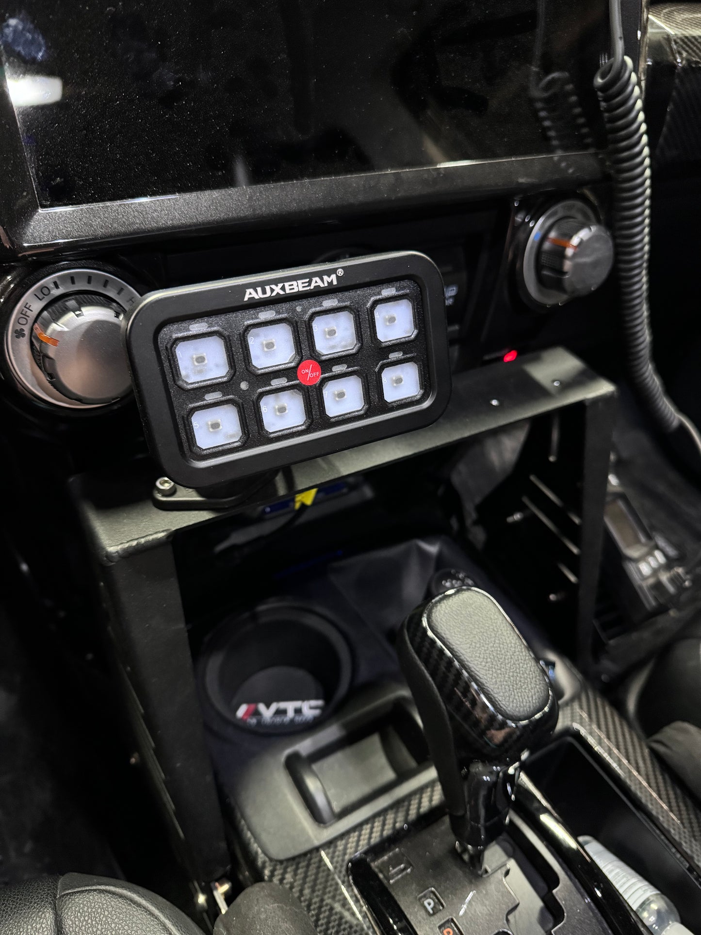 An Auxbeam switch panel mount, featuring an 8-gang switch panel installed in a vehicle's interior.