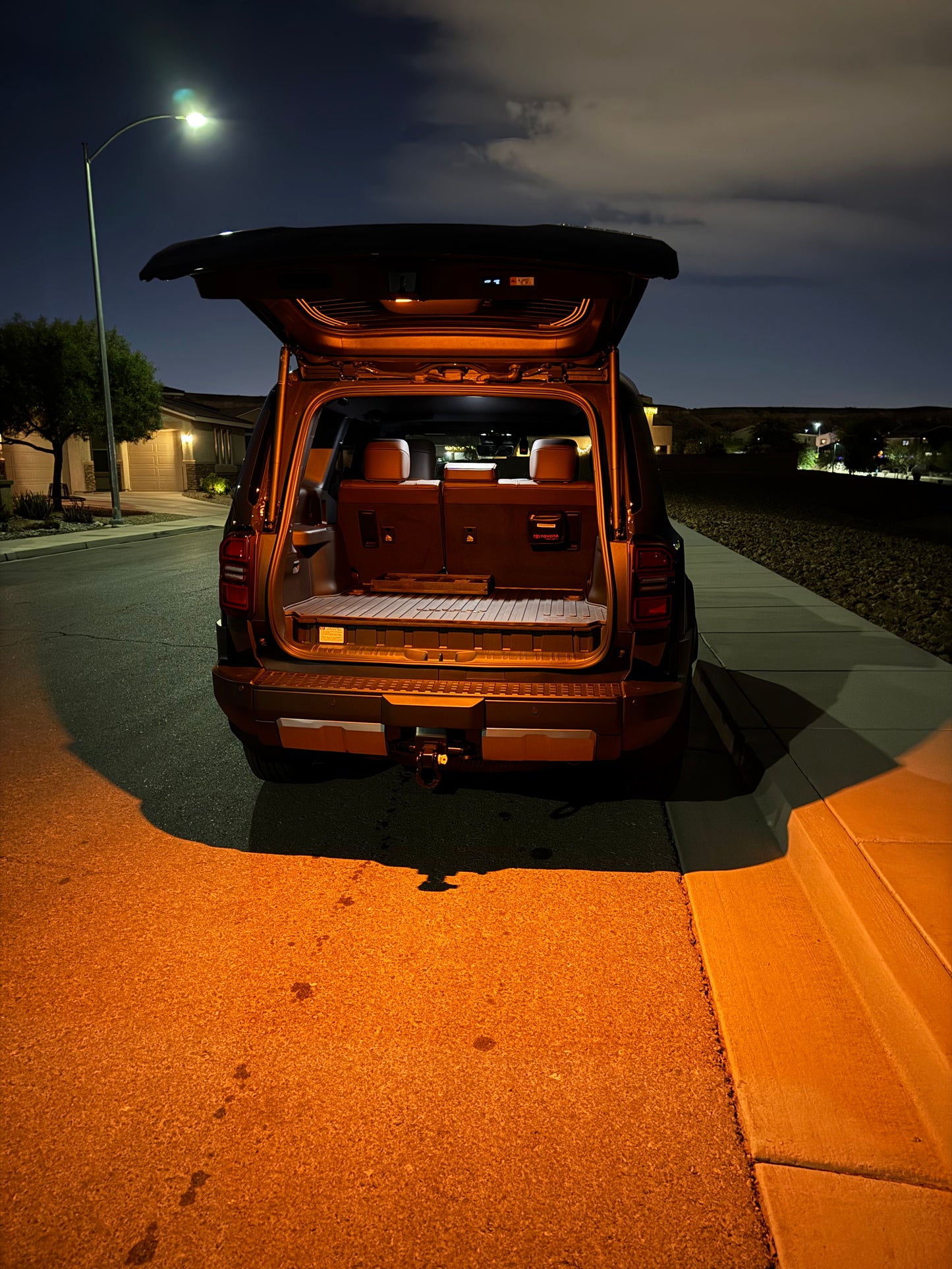 A switchable LED hatch light for Land Cruiser LC250/GX550 placed on a textured surface with the text 'LAND CRUISER' visible.
