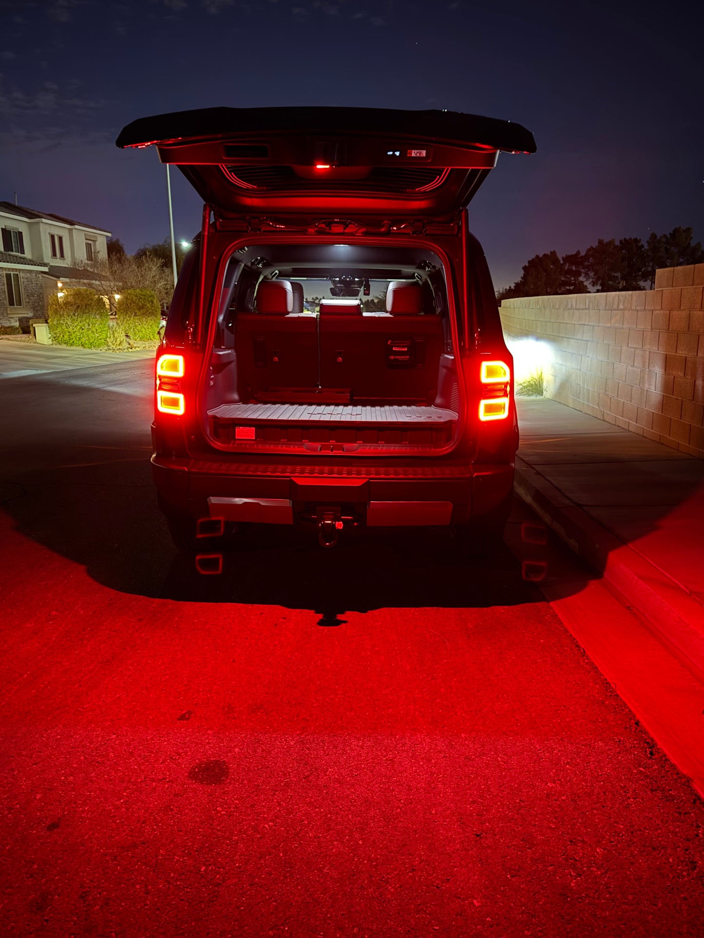 A switchable LED hatch light for Land Cruiser LC250/GX550 placed on a textured surface with the text 'LAND CRUISER' visible.