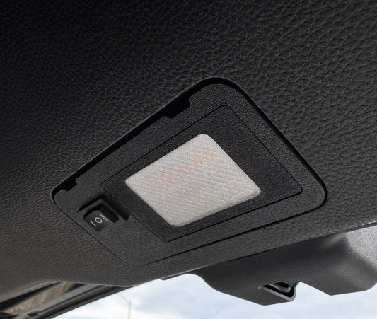 A switchable LED hatch light for Land Cruiser LC250/GX550 placed on a textured surface with the text 'LAND CRUISER' visible.