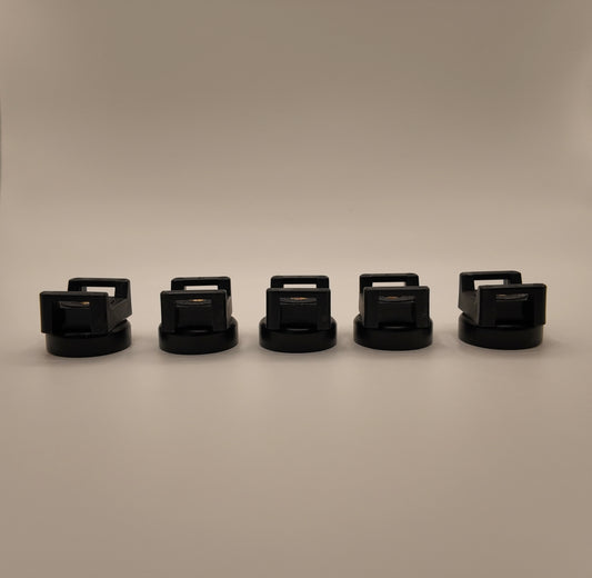 five black cylindrical objects with handles arranged in a row on a beige background