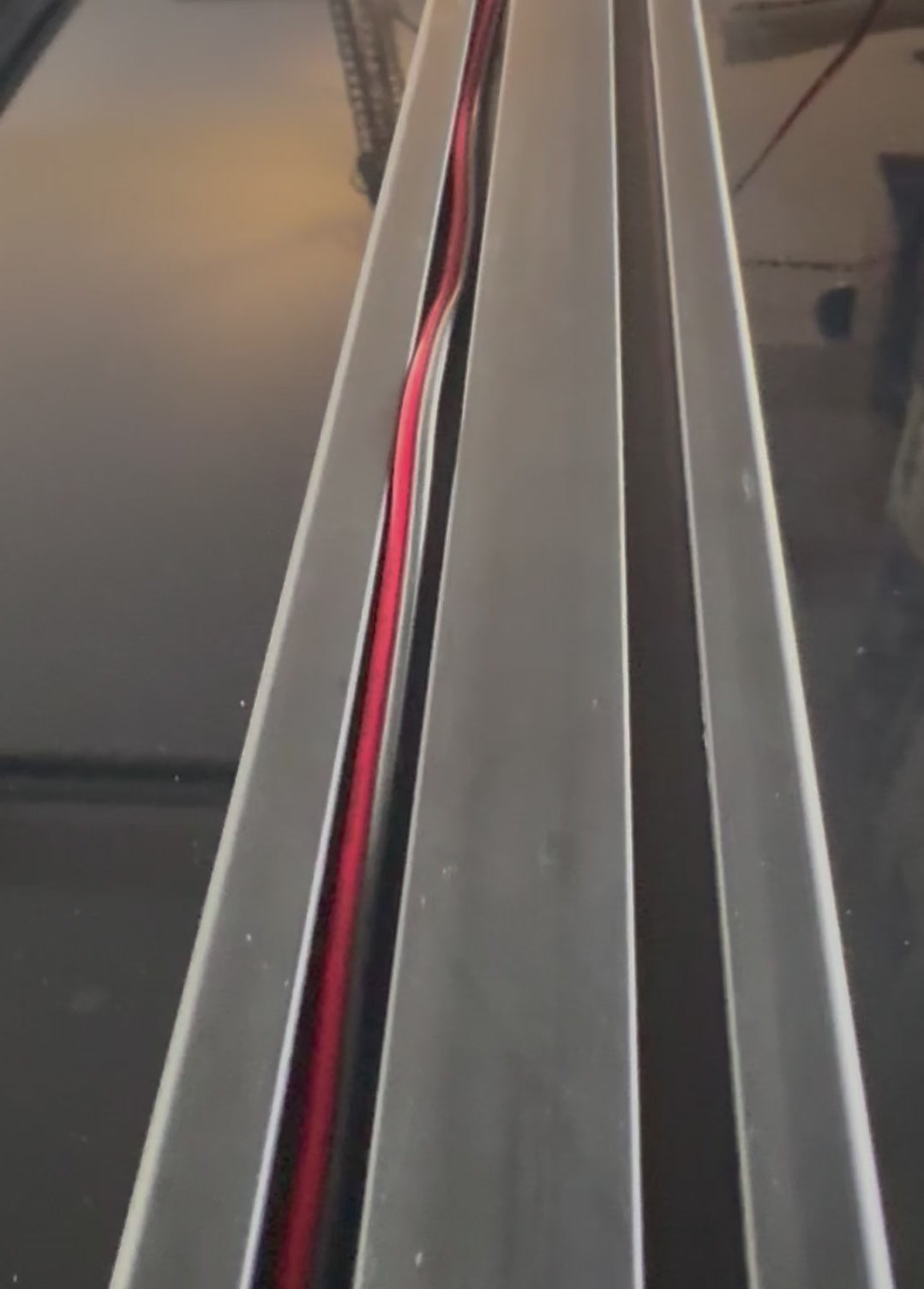 A set of black plastic wire hiders installed on a vehicle roof rack, designed to manage and route wiring along the cross bars.
