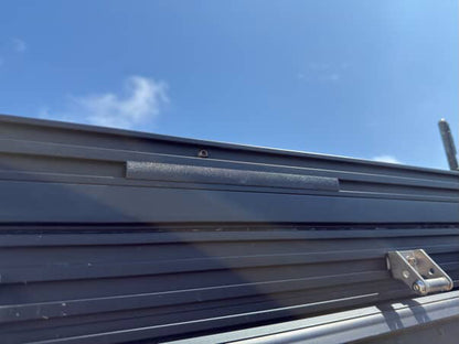 A set of black plastic wire hiders installed on a vehicle roof rack, designed to manage and route wiring along the cross bars.