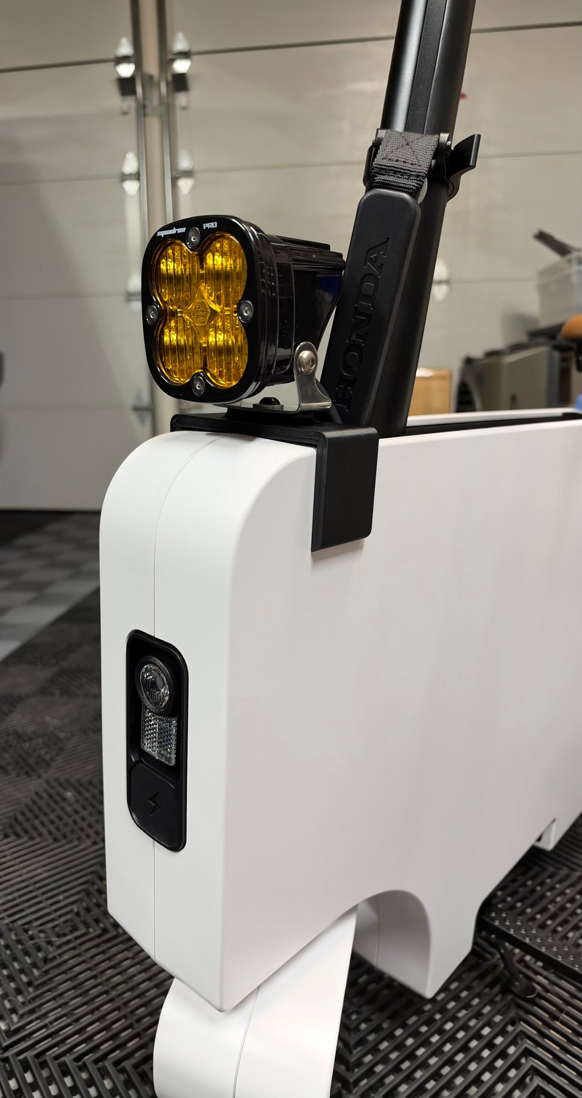 Honda Motocompacto with Baja Designs Squadron Pro amber LED light installed on black Obisan3D universal accessory mount above the factory headlight.