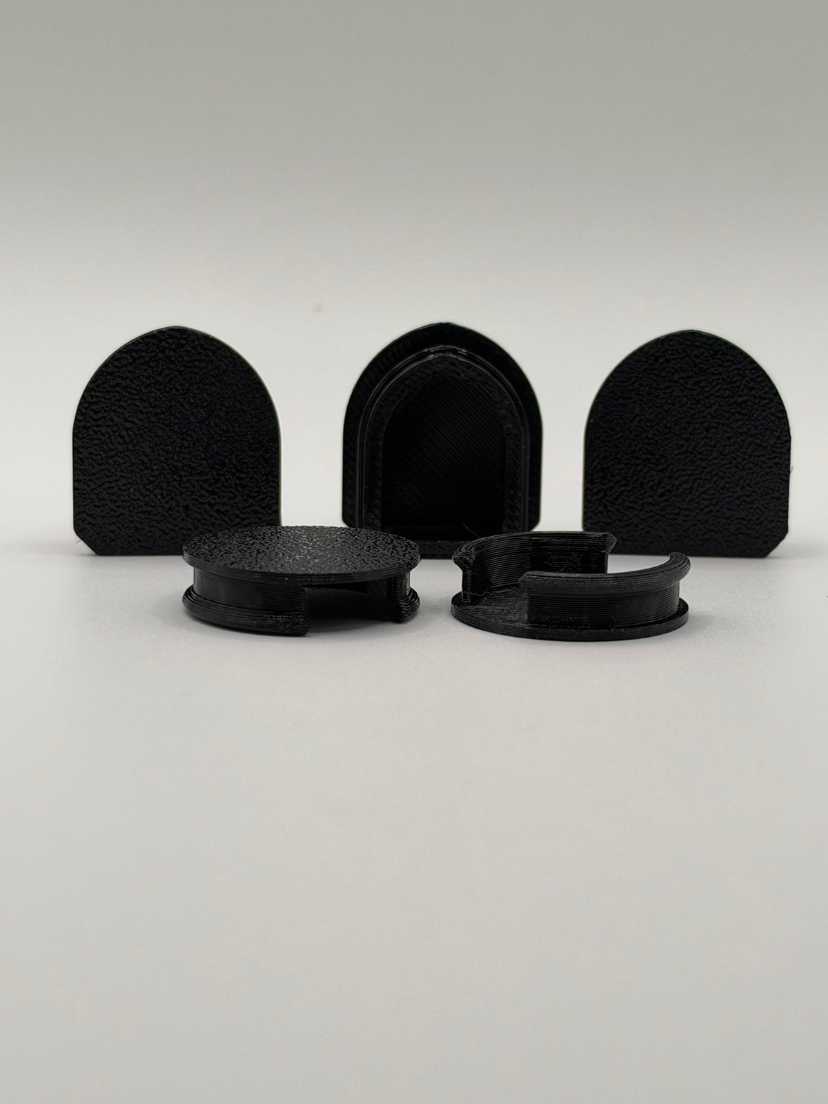 Five black 3D-printed Acura NSX engine garnish mounting hole covers showing their low-profile snap-in design