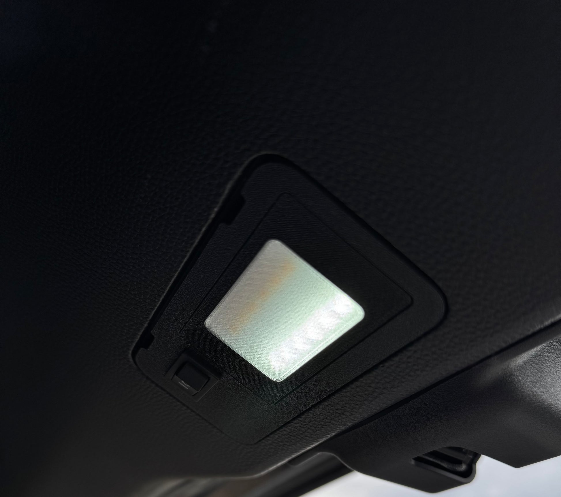 A switchable LED hatch light for Land Cruiser LC250/GX550 placed on a textured surface with the text 'LAND CRUISER' visible.
