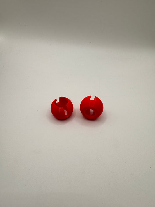 Two small glossy red plastic snap hooks or wall pegs displayed vertically on a plain off-white background.